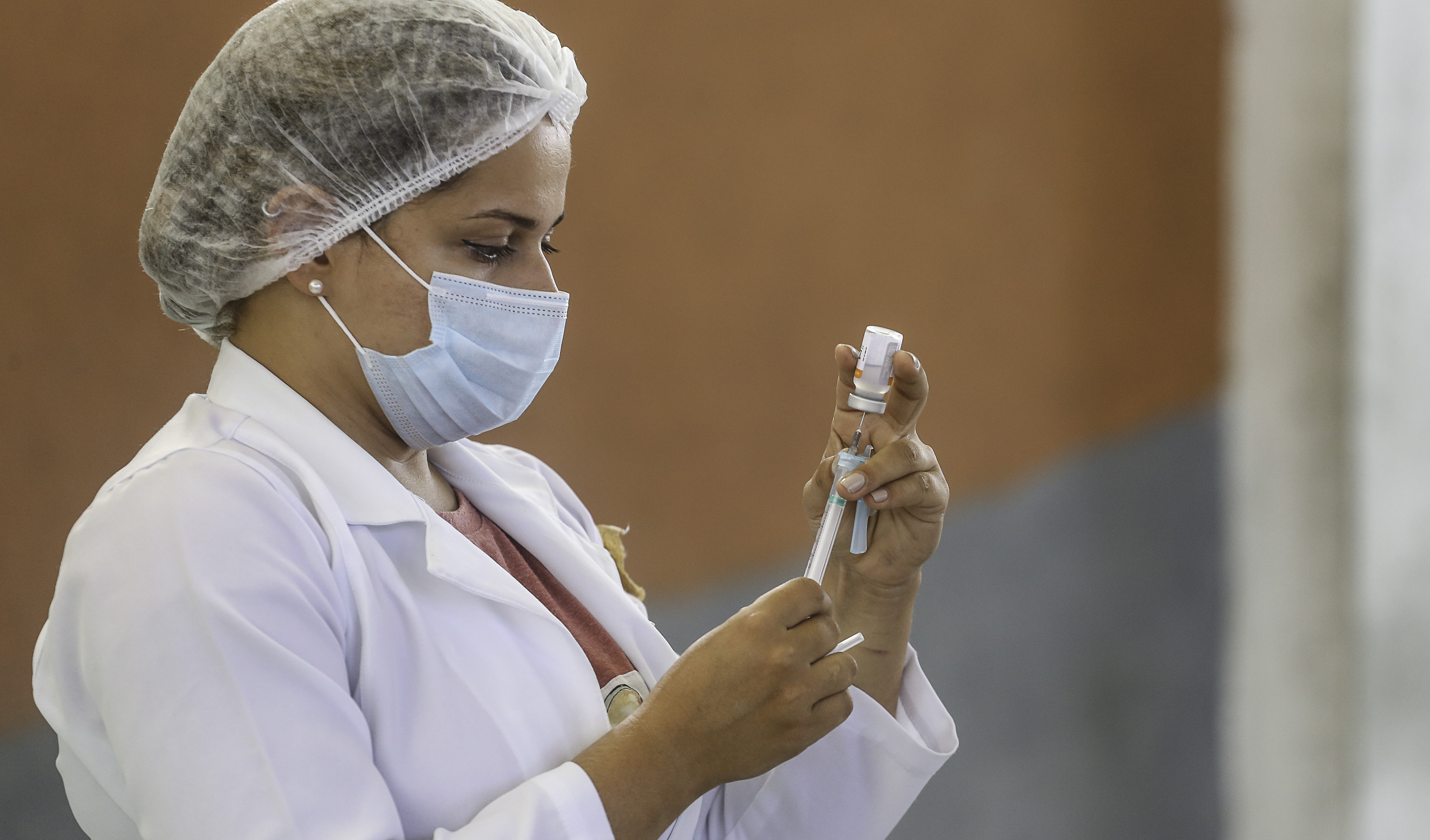 enfermeira ajusta uma seringa de vacinação
